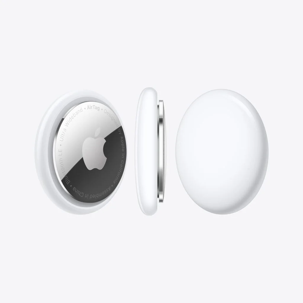 An Apple AirTag, shown in a partially split view, revealing the internal components including the battery and logo.