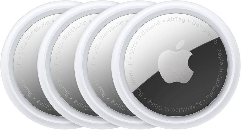 Apple AirTag Review: Four AirTags in a row, showcasing the silver Apple logo and product details, as examined in our comprehensive review